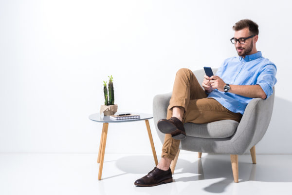 Mann sitzend mit Smartphone